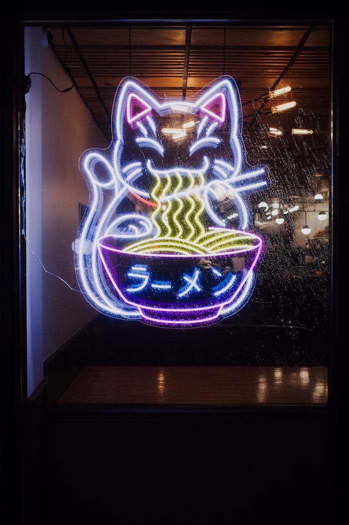 Vibrant neon sign of a cat eating ramen, ideal for restaurant themes.